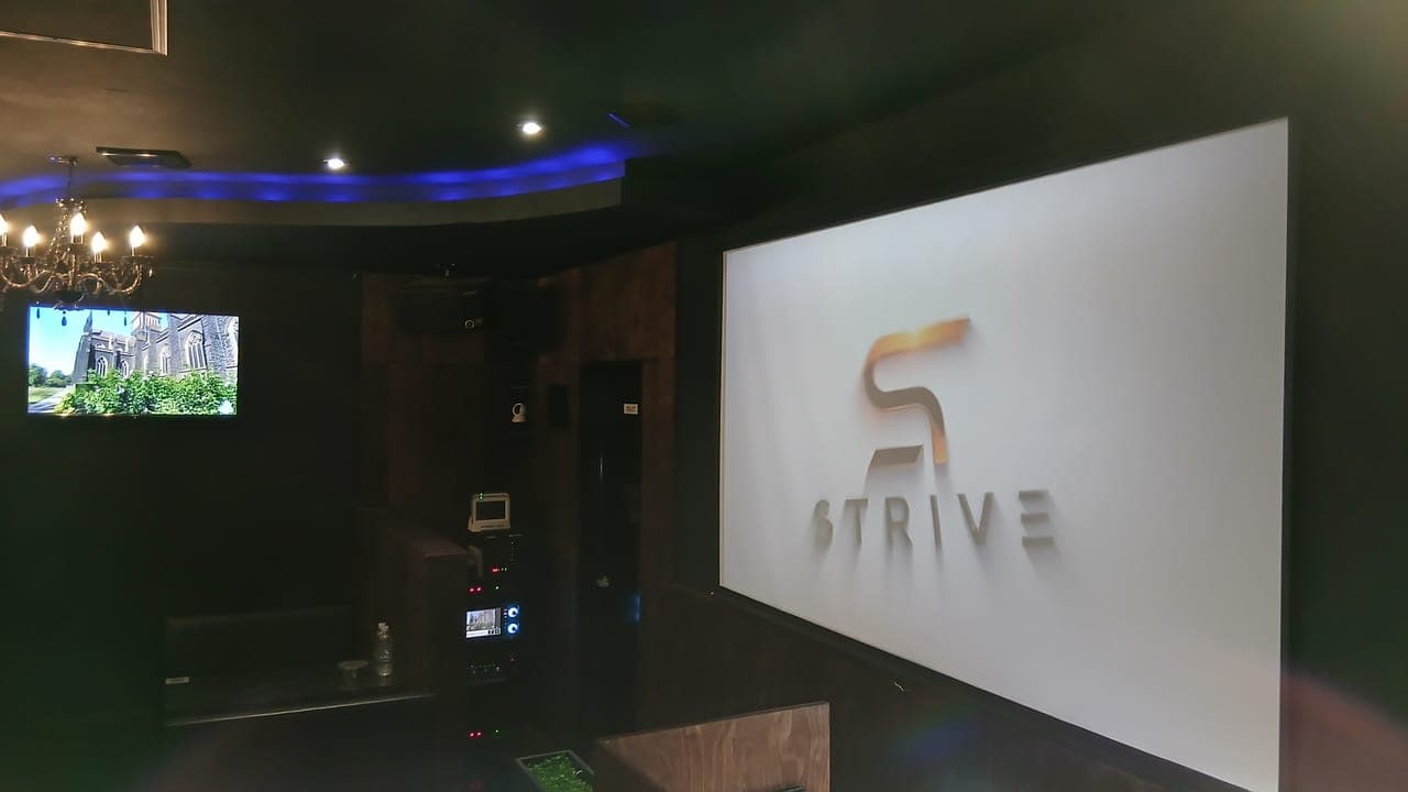 ホストクラブSTRIVEの店内|金のSTRIVEロゴが輝く壁面とシャンデリア